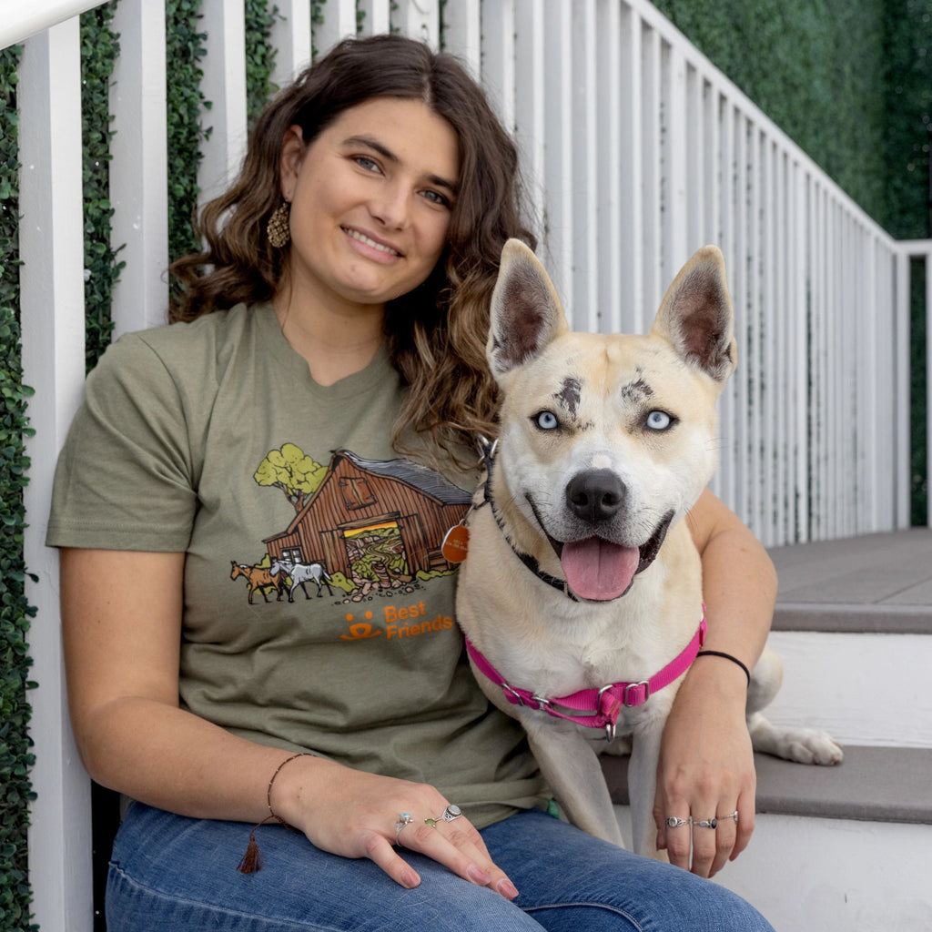 Woman sitting on stairs with her arm around a dog