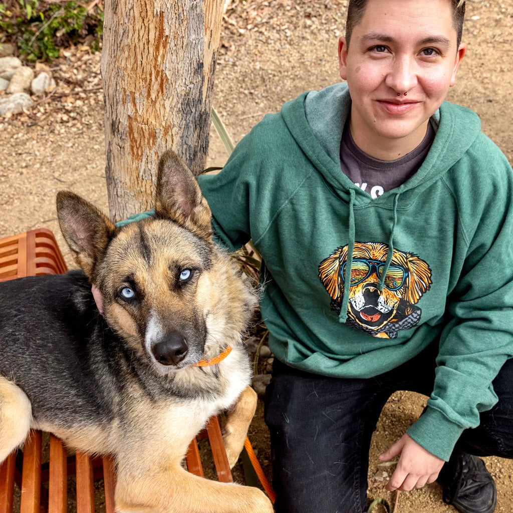 Person in "Wild Tribute" hoodie next to a dog