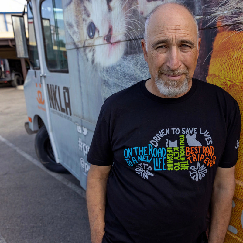 Man wearing Best Friends Animal Society in front of Best Friends Animal Society vehicle