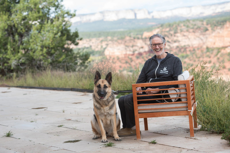 Person in BFAS sweatshirt on a bench with a dog