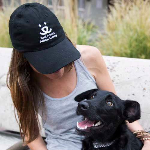 Person in Best Friends Animal Society hat with dog